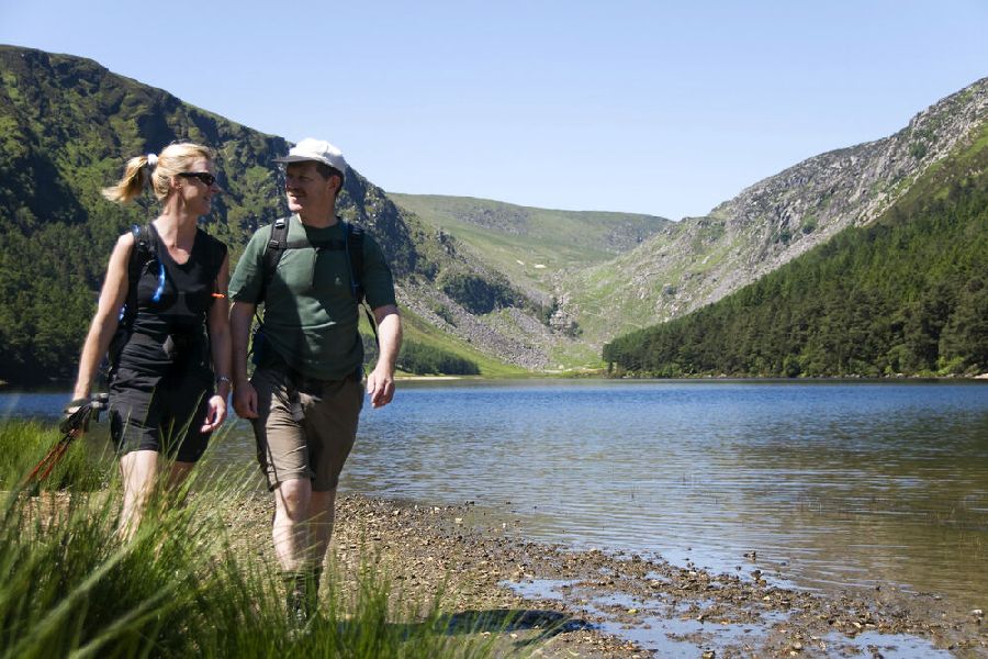 Twee wandelaars in een dal met een meer in Wicklow