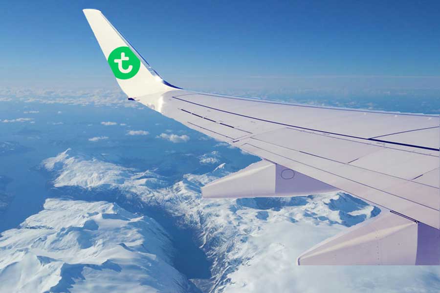 Vliegtuig van Transavia boven de besneeuwde bergen