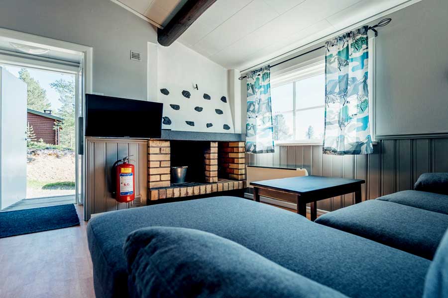 Woonkamer met open haard of houtkachel in een Gammelbyn chalet 