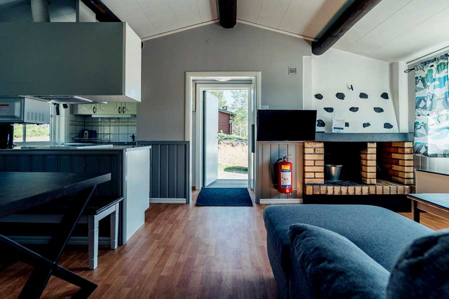 Woonkamer met open haard of houtkachel in een Gammelbyn chalet 